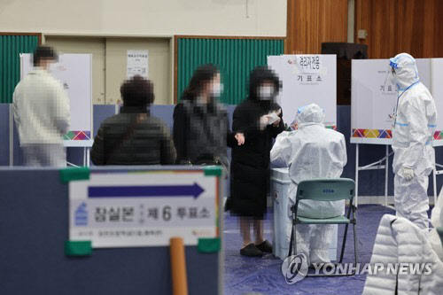 제20대 대통령선거일인 9일 오후 서울 송파구 잠전초등학교 체육관에 마련된 잠실본동 제5투표소에서 코로나19 확진·격리 유권자들이 투표하고 있다. <연합뉴스>